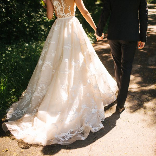 Bride and groom holding hands and walking with their backs turned