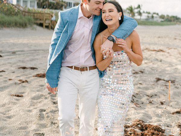 bride and groom holding hands on a beach