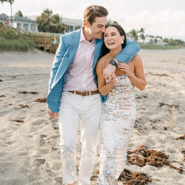 bride and groom holding hands on a beach