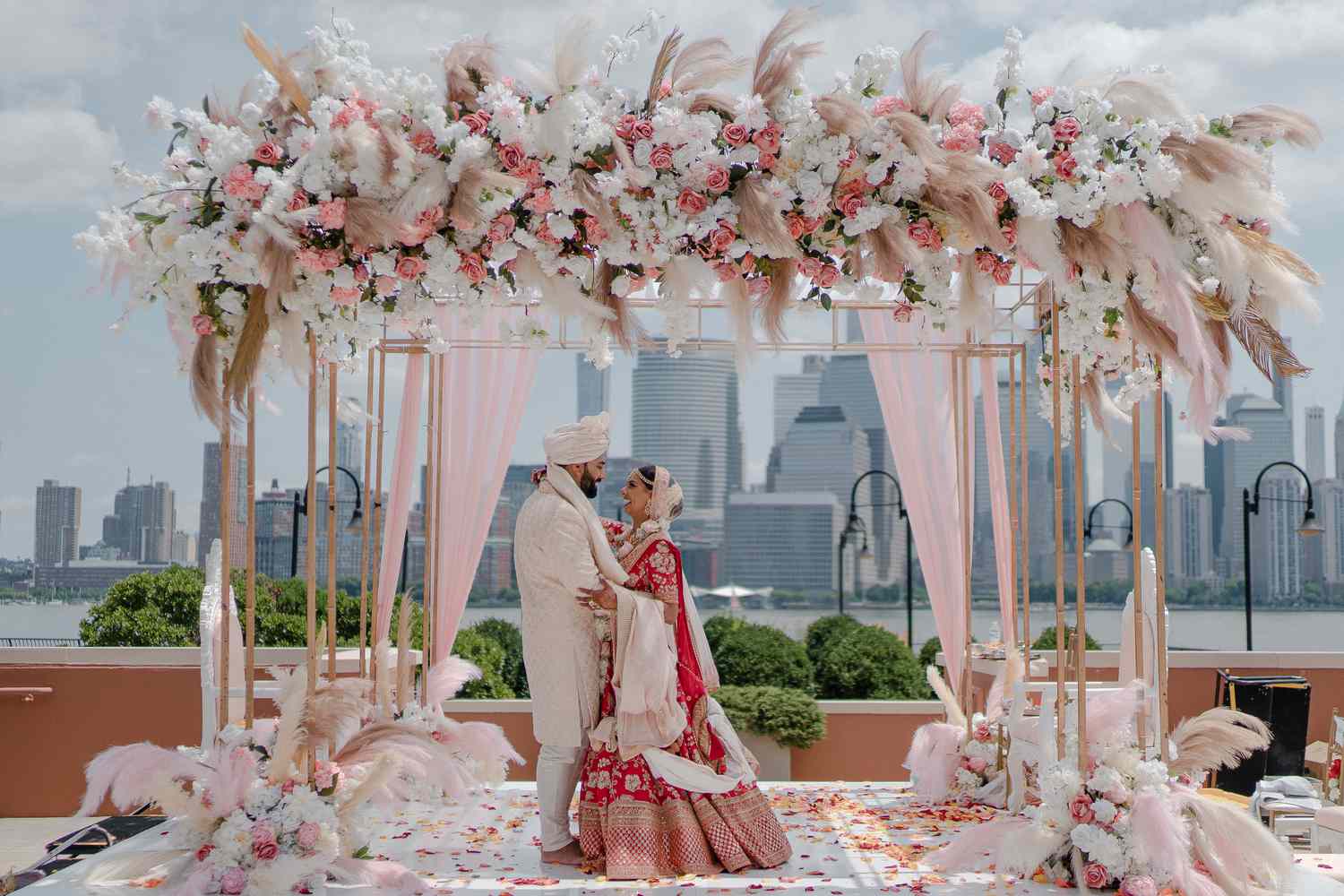 couple embracing under a pink boho mandap