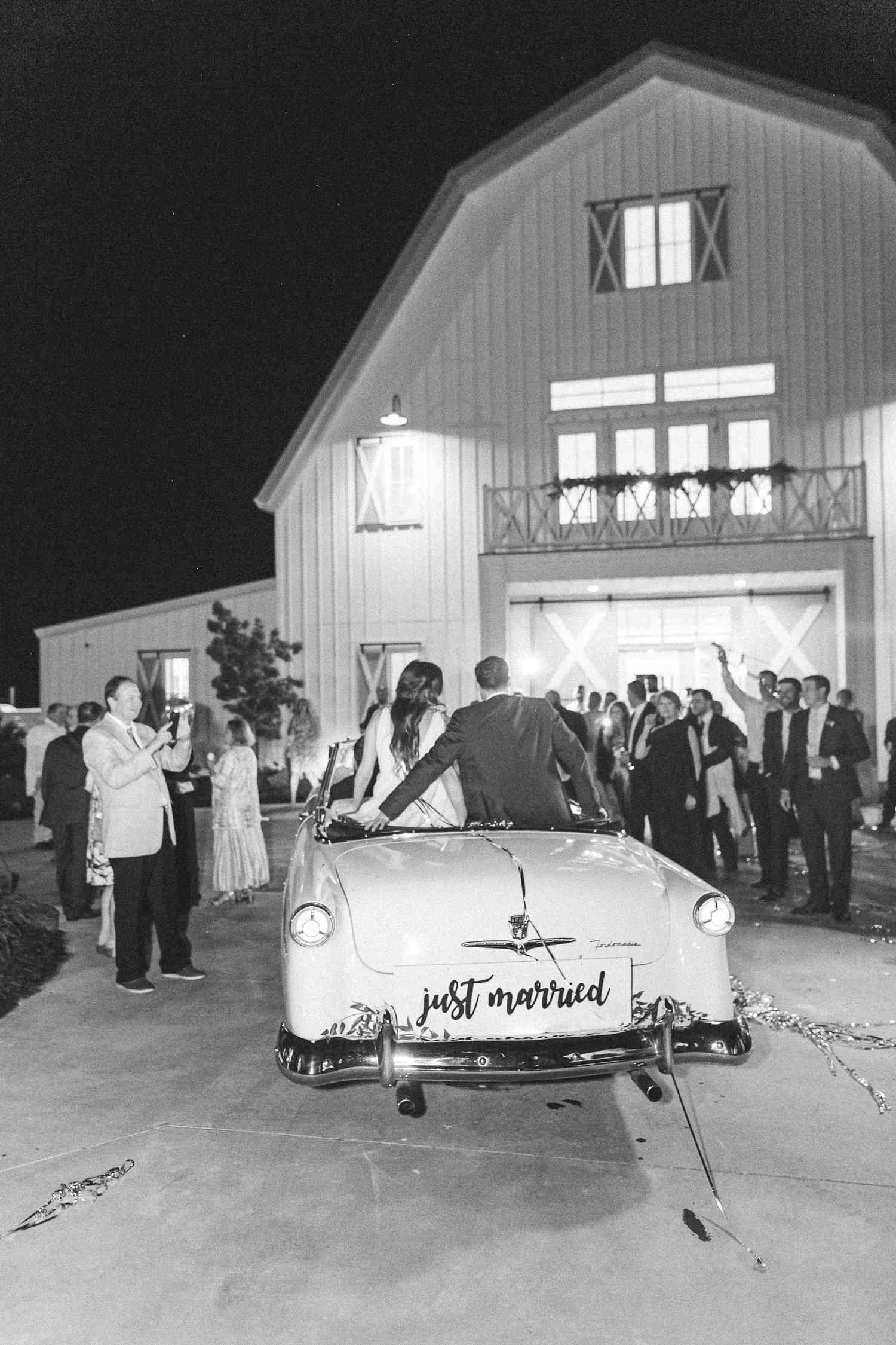 Bride and groom riding in their getaway car