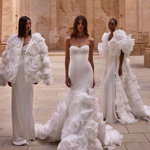 Three models wearing Milla Nova wedding dresses with 3D rose accents