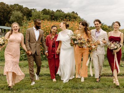 Bride and Wedding Party in Mismatched Attire Walking Through Flower Field