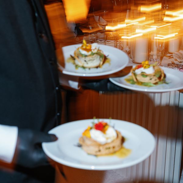 Waiter Carrying Plated Dinner to Guests During Wedding Reception