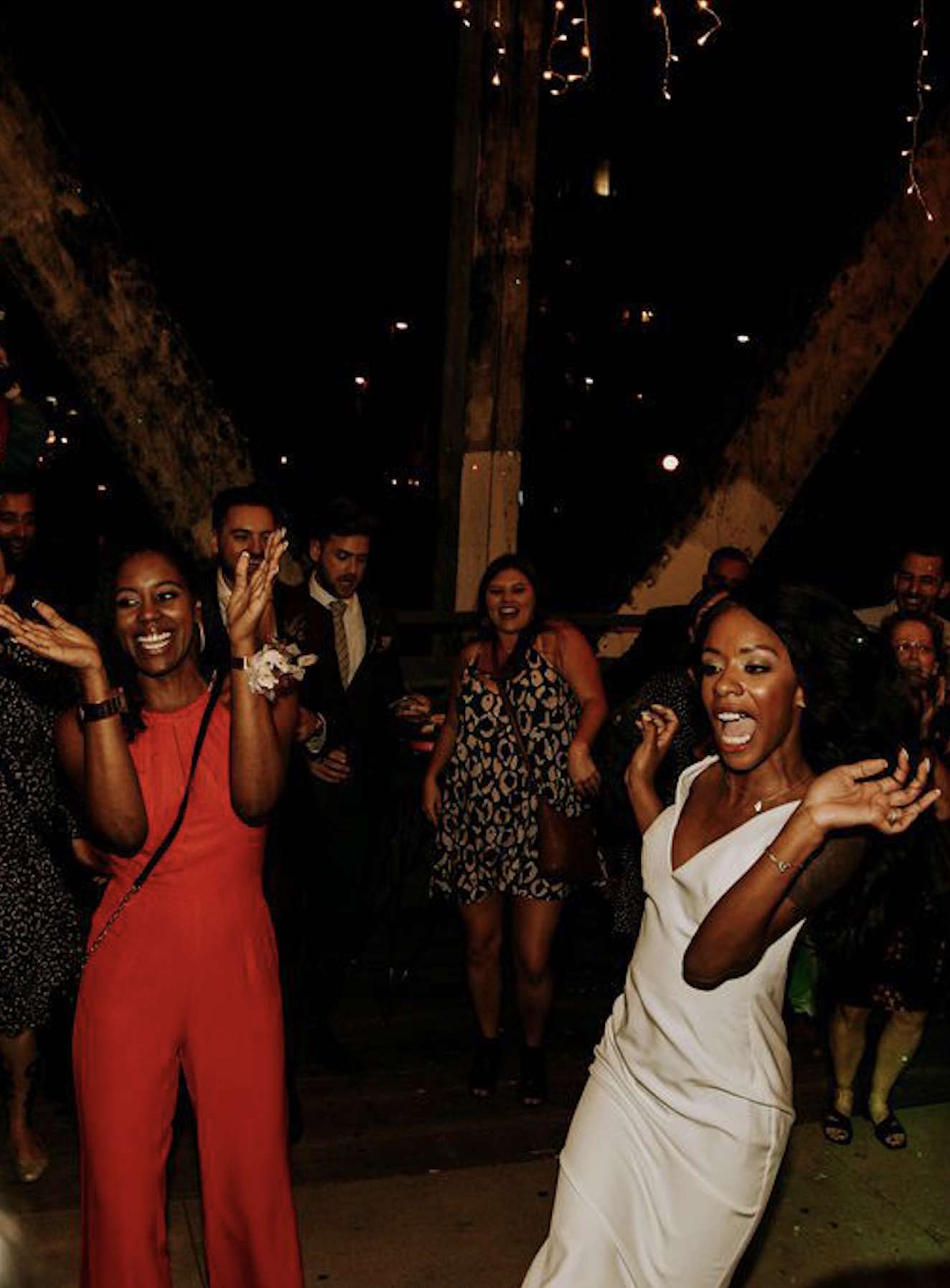 bride and wedding guest dancing at an evening wedding reception outdoors