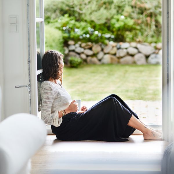 Young woman sitting in doorway looking out
