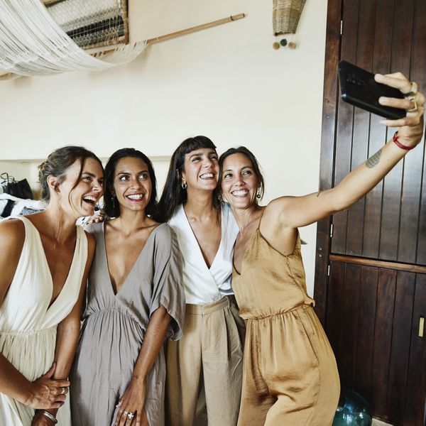 Four female wedding guests dressed for a casual wedding in simple dresses and matching sets