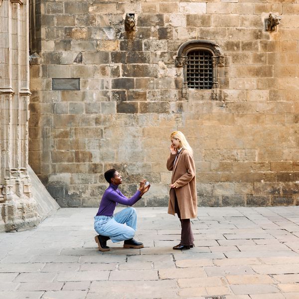 A couple getting engaged in a city.