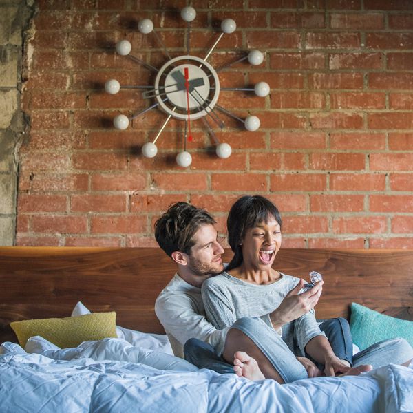 man proposing to woman in bed