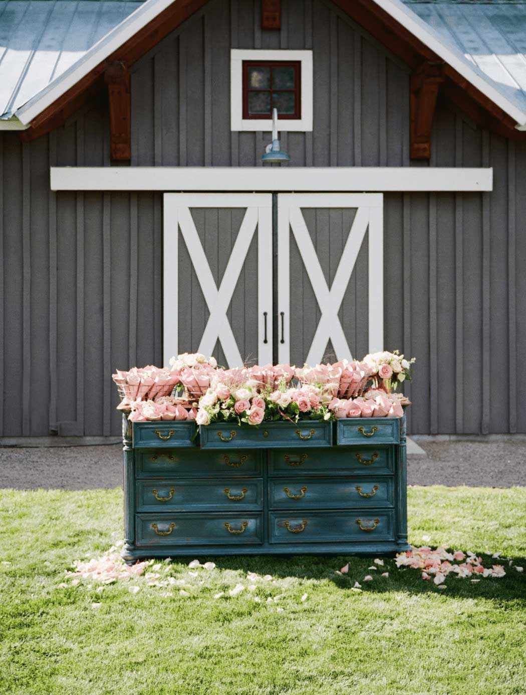 Rustic floral display of pink roses in blue dresser