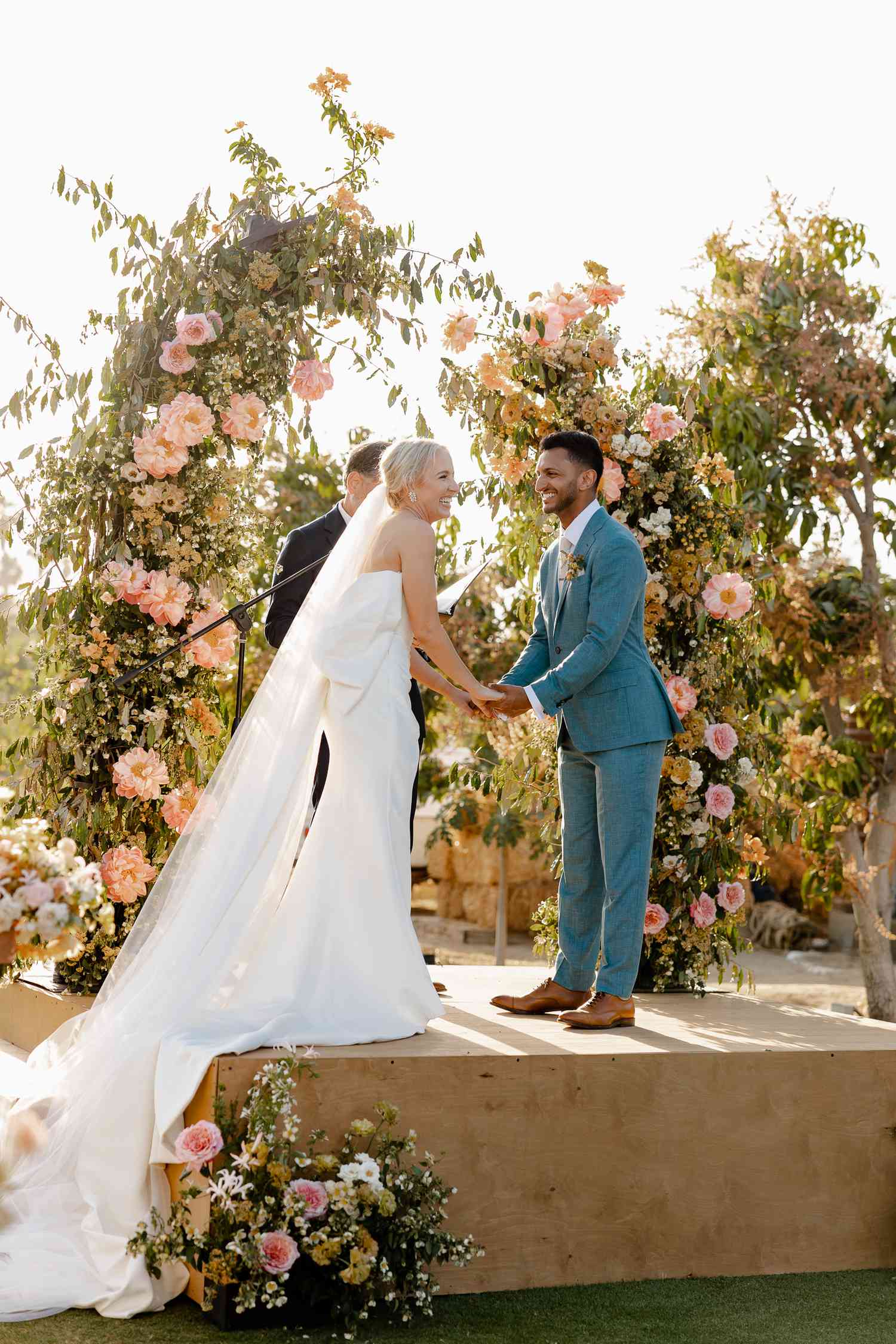Bride and groom holding hands and exchanging vows at the altar