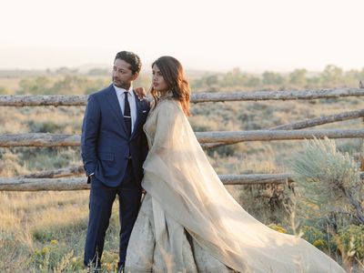 Groom in Blue Suit and Bride in Gold Gown Posing for Wedding Portrait at Sunset