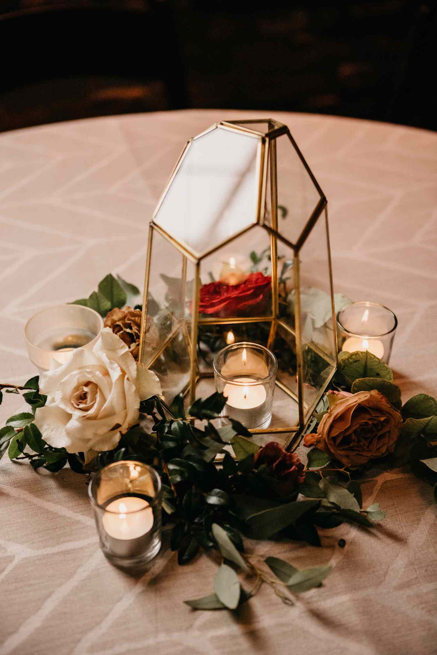 romantic lantern centerpiece with small votive candles and roses