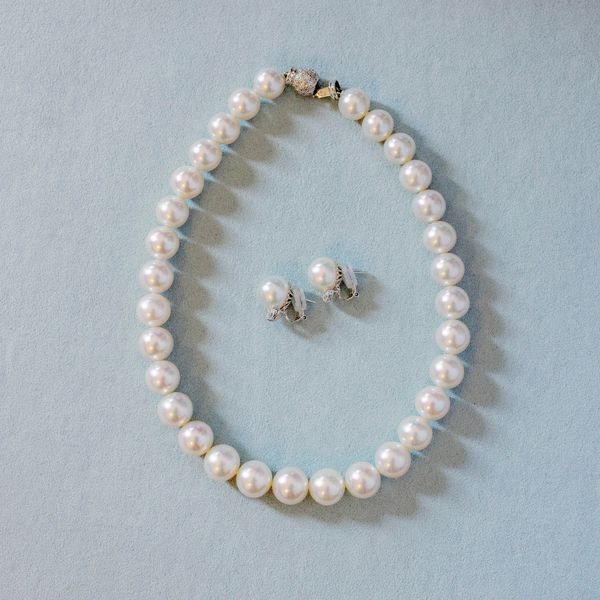 flat lay image of a pearl necklace and pearl earrings