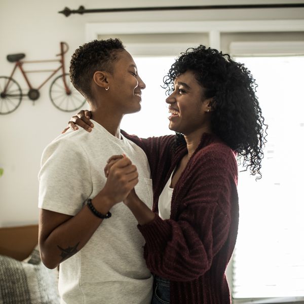 Happy Young Couple Holding Hands and Smiling in Home