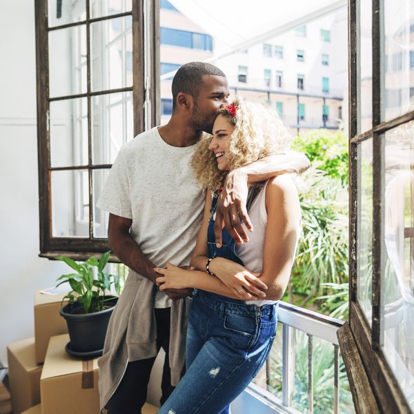 Happy Young Couple Kissing by Window and Clearly in Love