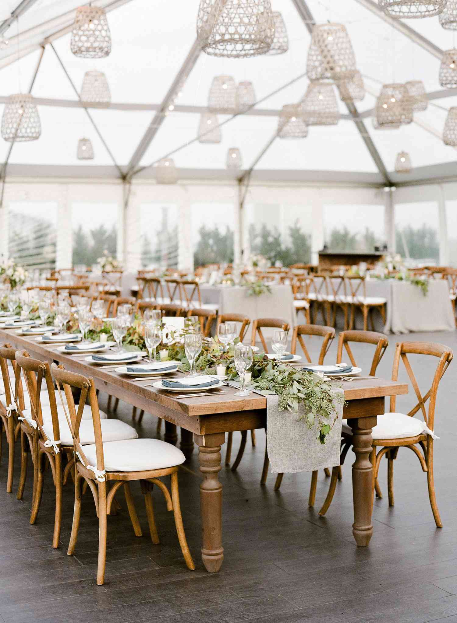 Long guest tables with table runner adorned with greenery