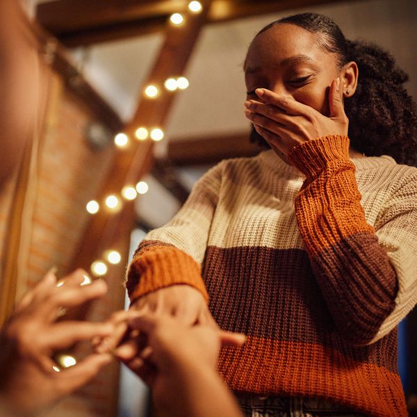 Woman Covers Her Face With Her Hand During a Holiday Engagement