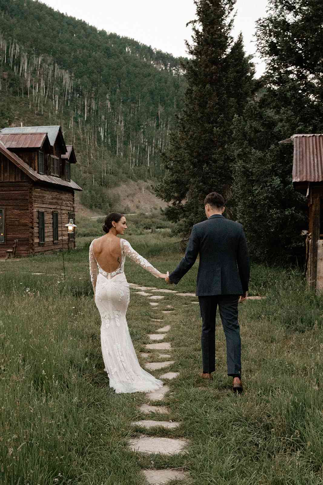 Couple Holds Hands While Looking at the Mountains During Their Destination Elopement in Colorado