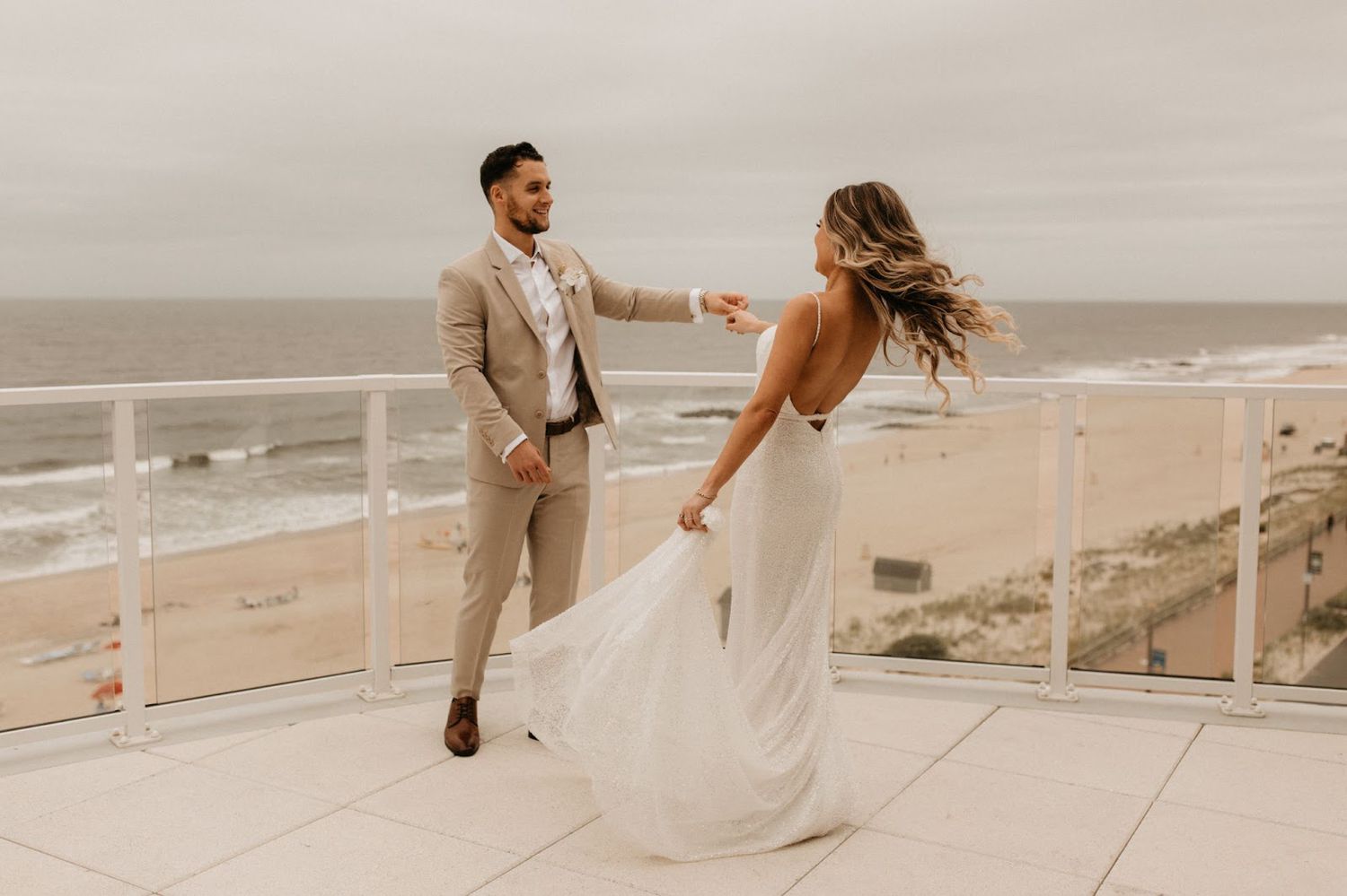 bride and groom dancing on rooftop near beach