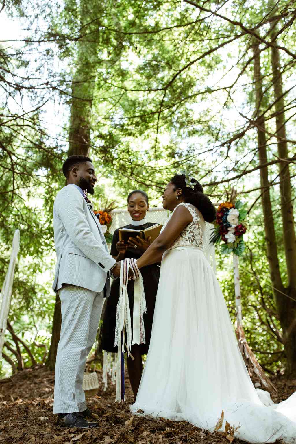 Bride and Groom Holding Hands During Traditional Handfasting During Christian Wedding Ceremony
