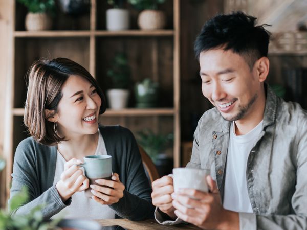 Happy young couple having a coffee date in cafe, drinking coffee and chatting. 
