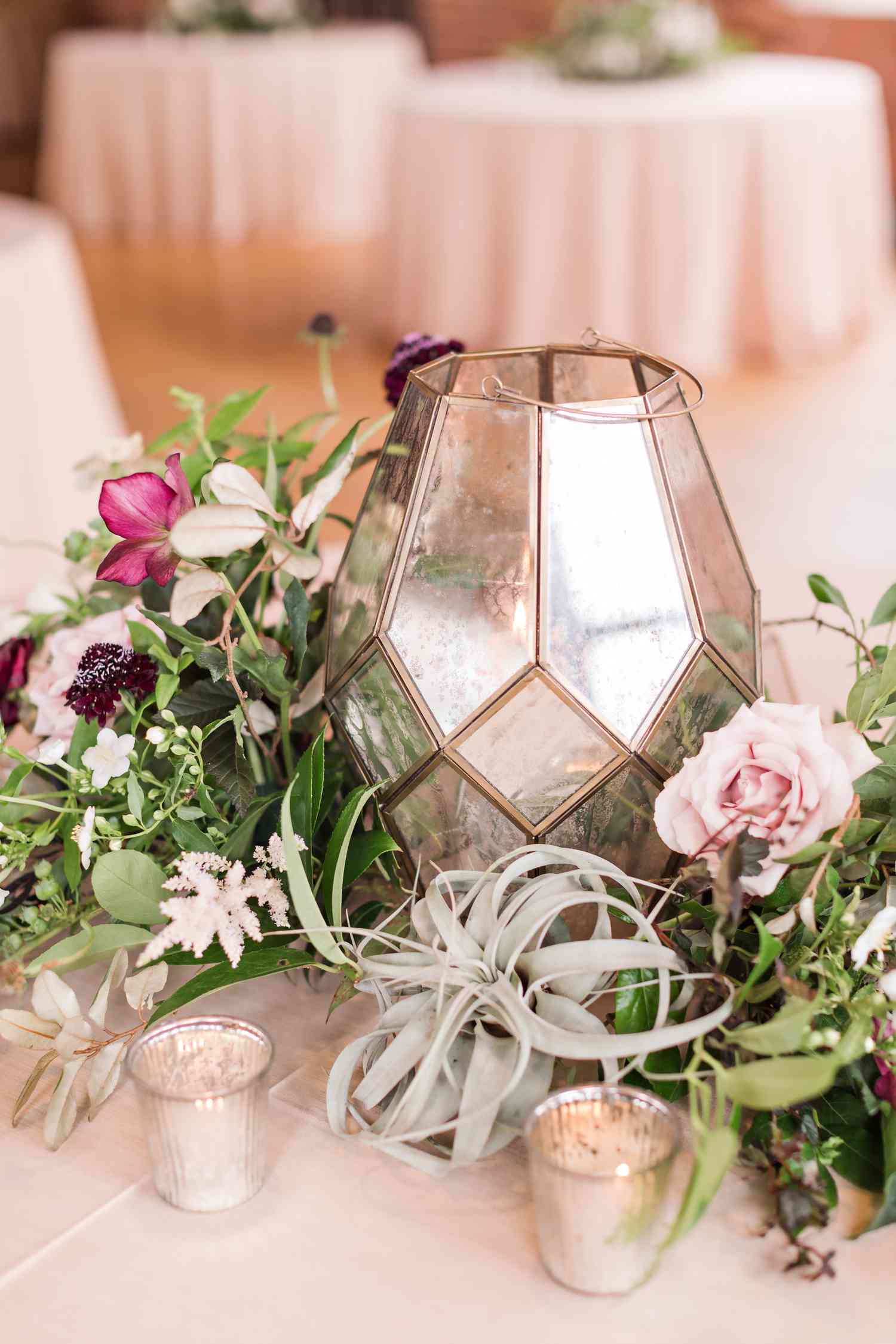rose gold lantern with greenery and flowers and smaller candle holders