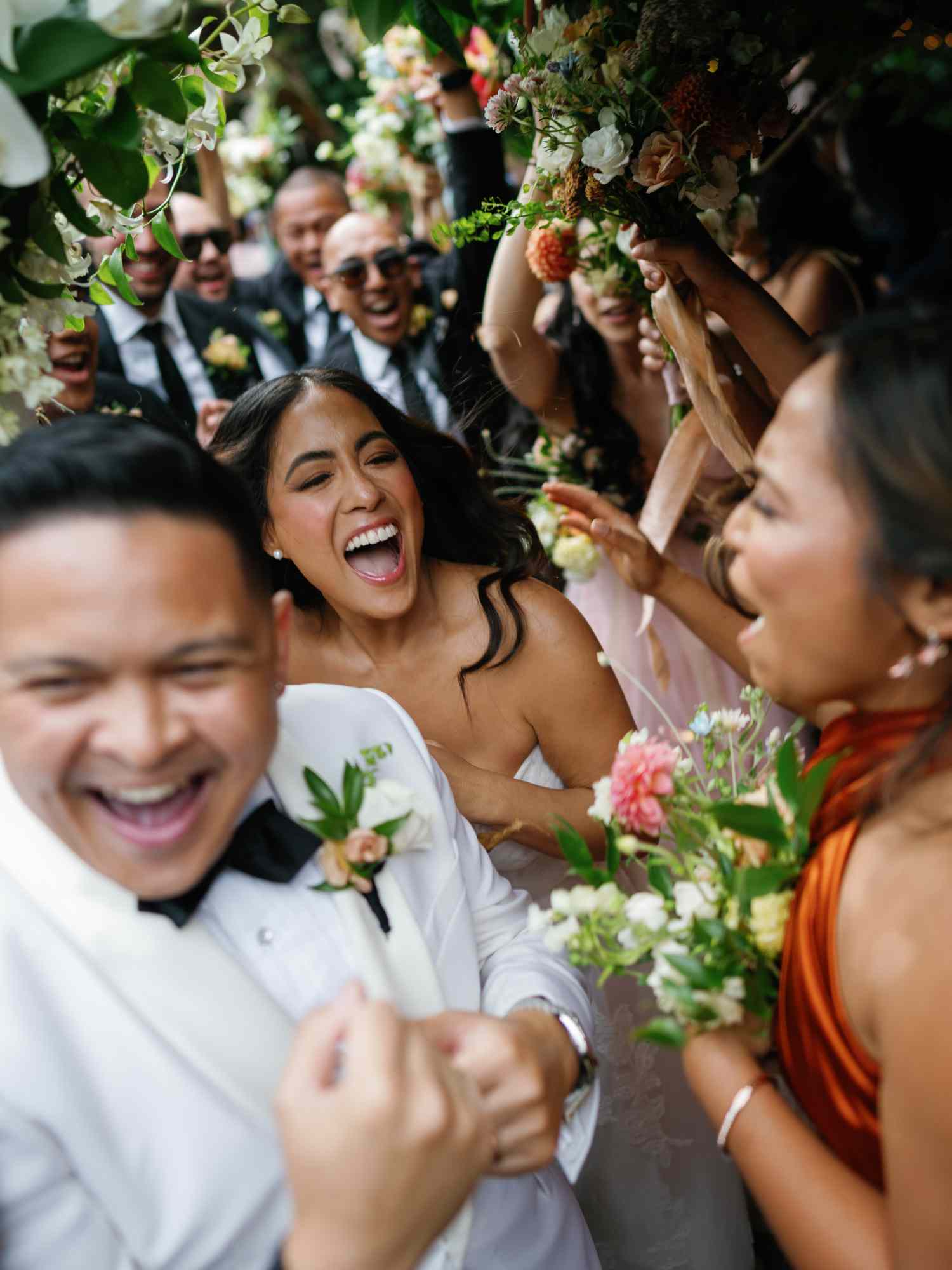 Bride and Groom Celebrating With Their Guests and Their Wedding Party During Their Wedding Entrance