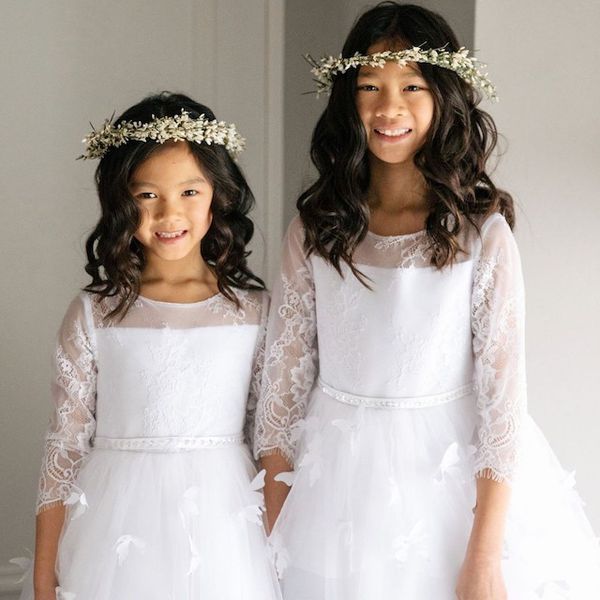 flower girls in white dresses with brown waves and flower crowns