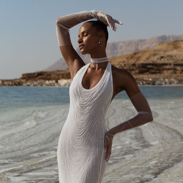 model wearing a pearl-encrusted halter-neck dress with tulle removable sleeves