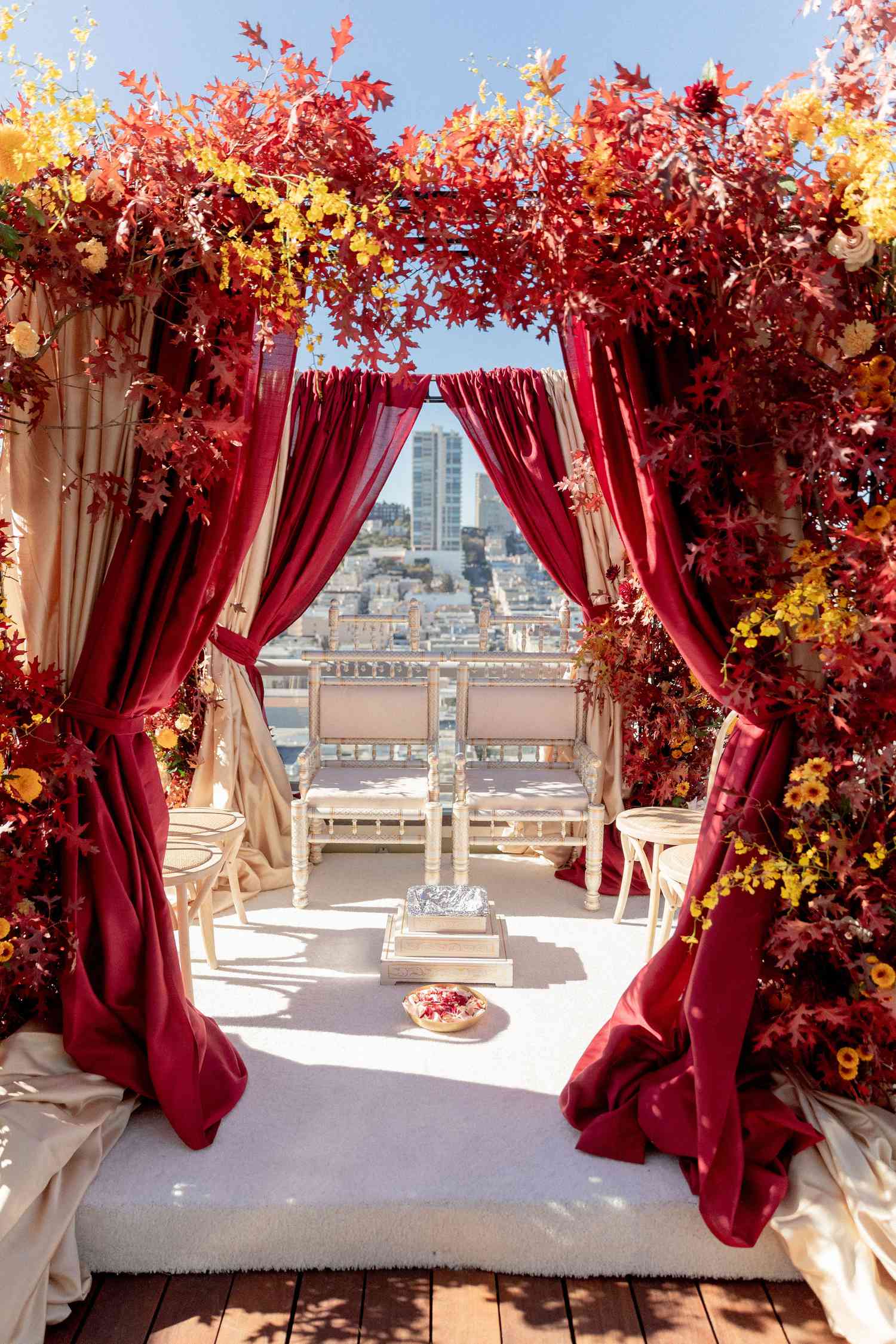 fall-inspired mandap decorated with red and yellow leaves