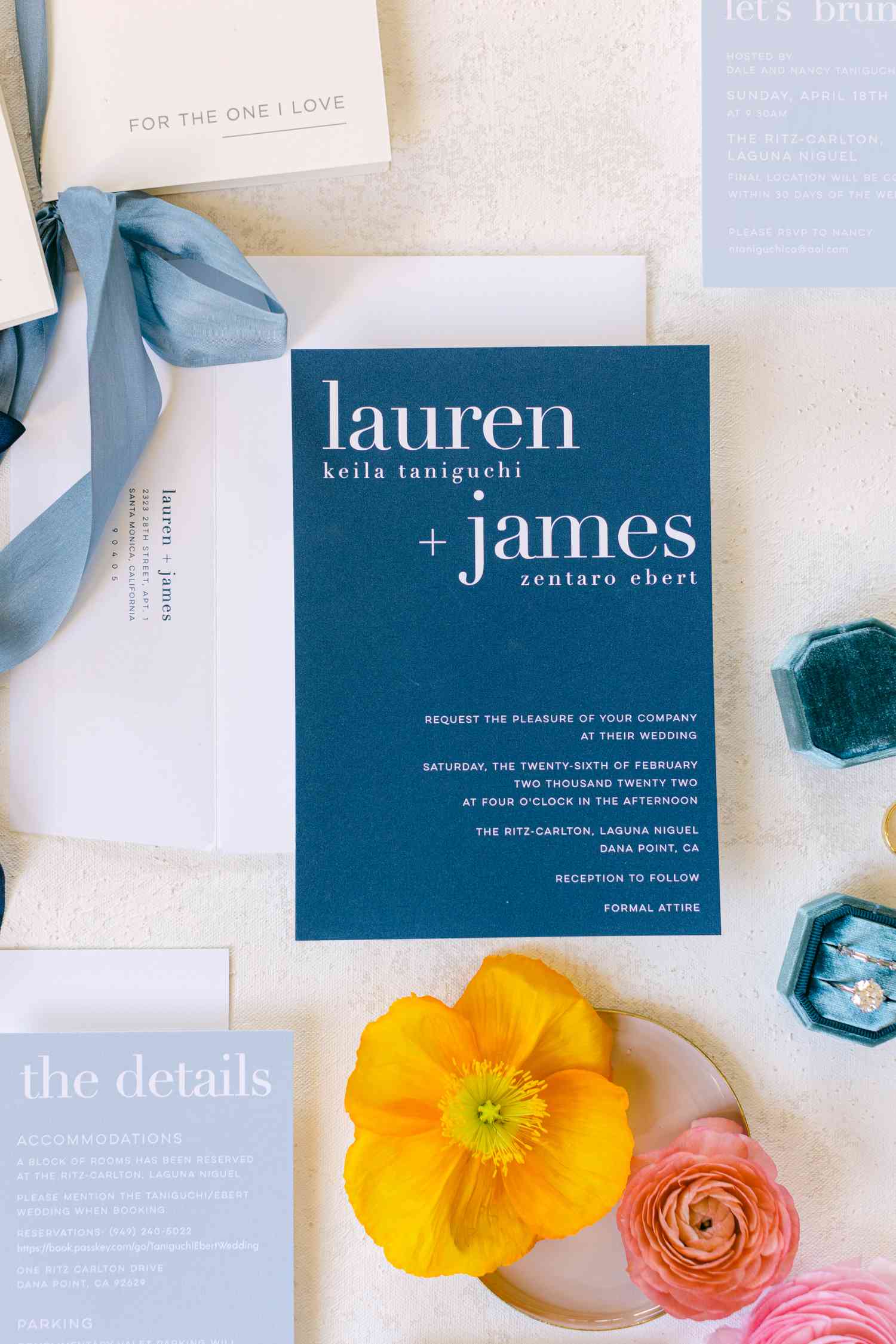 Indigo blue, light blue, and white invitation suite with blue ribbon and orange and pink florals