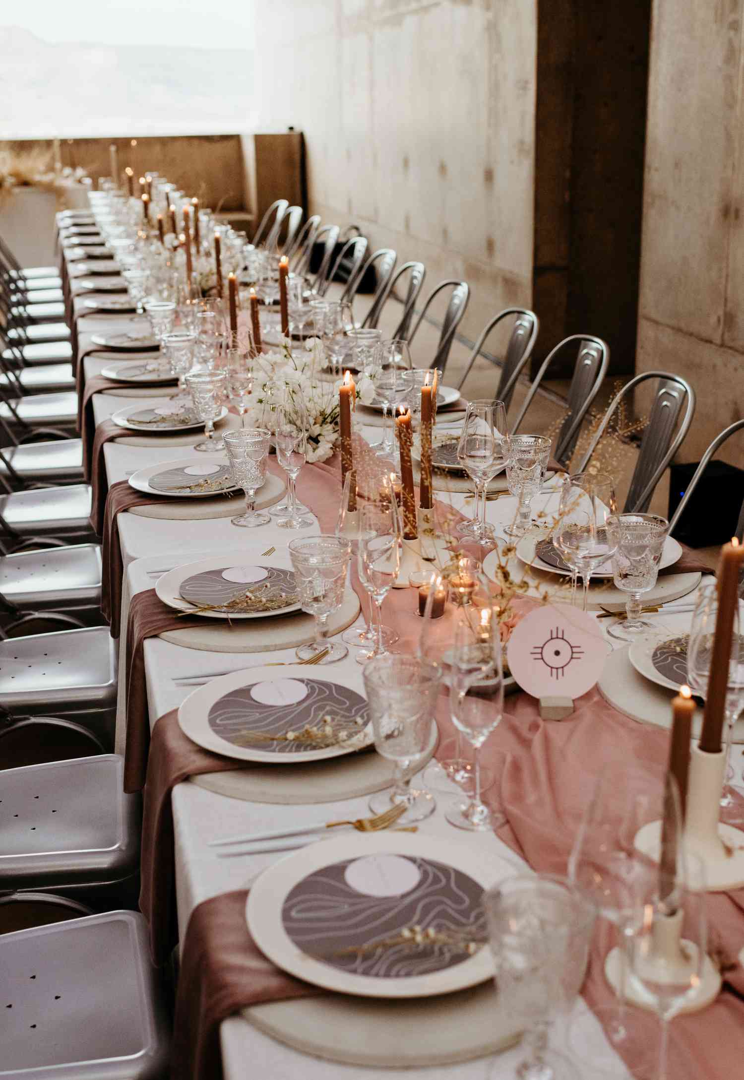 Long guest table with pink silk table runner bronze candles and neutral place settings