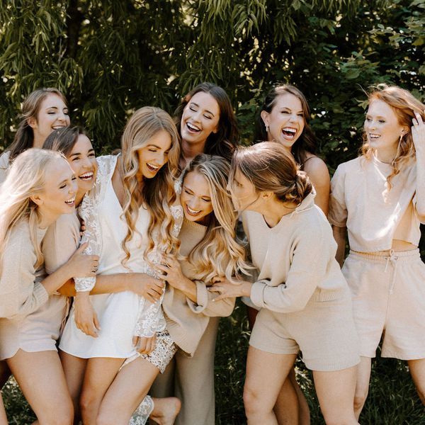 bride and bridesmaids in matching nude pajama sets laughing