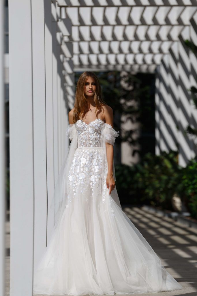 Model in strapless A-line gown with floral embroidered lace and tulle drop sleeves