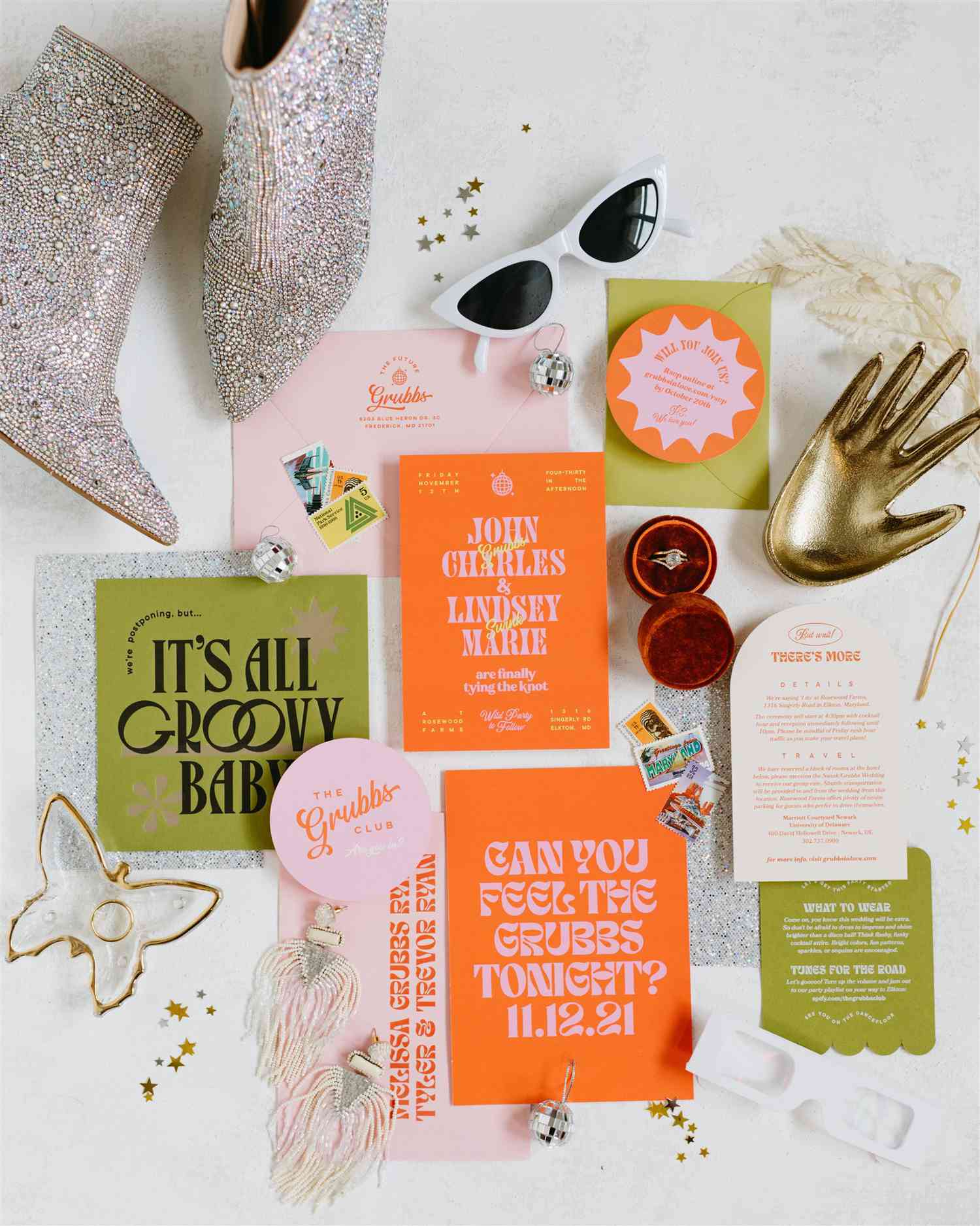 Invitation suite with orange, green, and pink paper inserts, a ring box, sparkling boots, sunglasses, earrings, and small disco balls