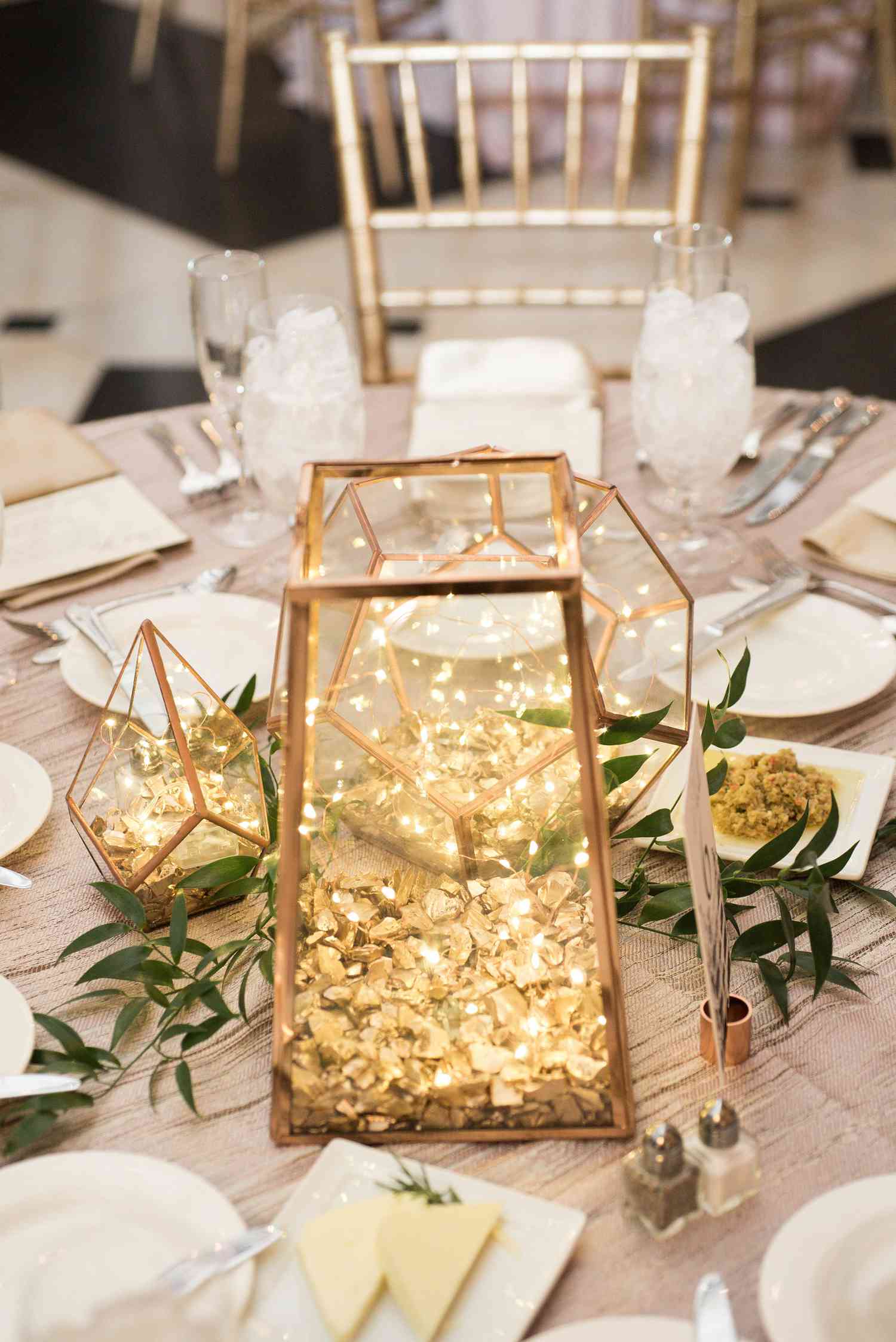 large gold lantern and smaller gold lantern filled with fairy lights