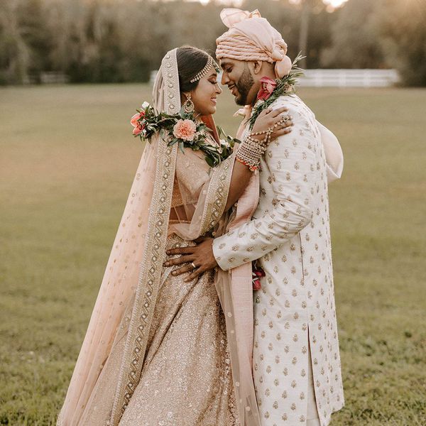bride and groom wearing traditional Hindu wedding attire in shades of ivory and blush pink