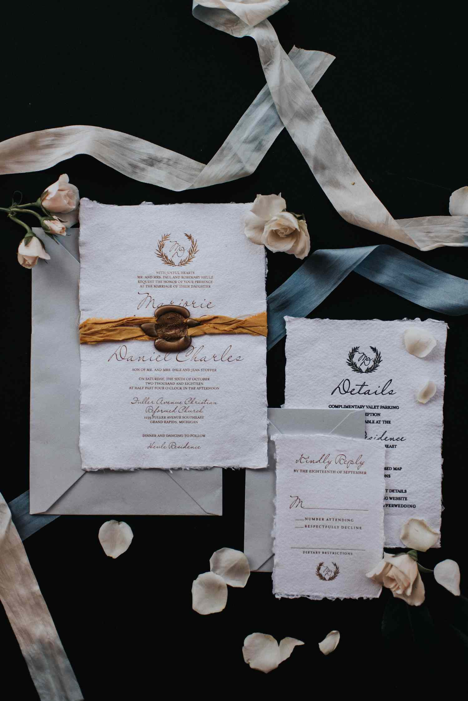 Delicate fall wedding invitation with ribbon, wax seal, roses, and a personalized crest.