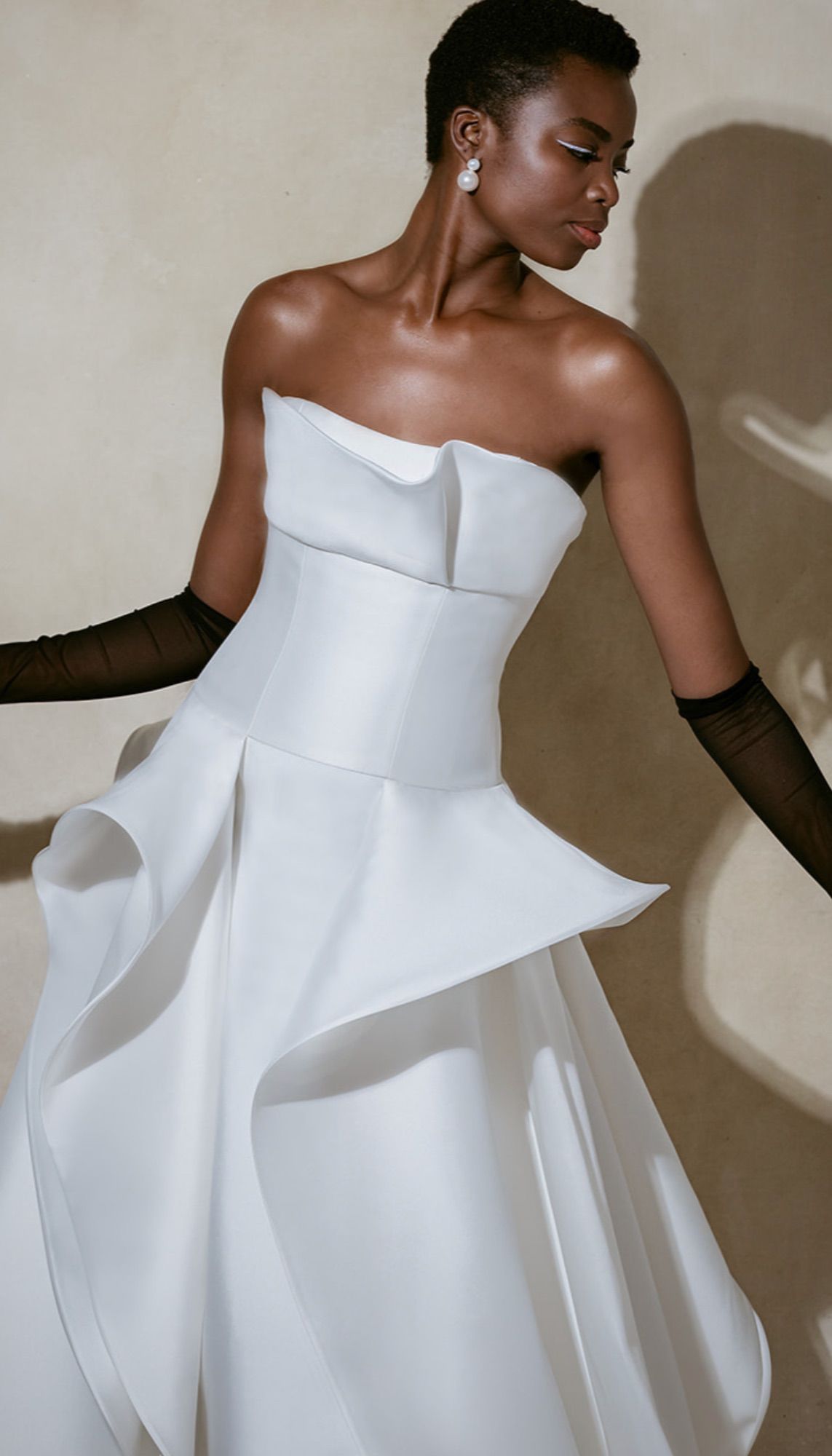 Ruffled White Wedding Dress With Strapless Corset Top, Black Gloves, and Pearl Earrings