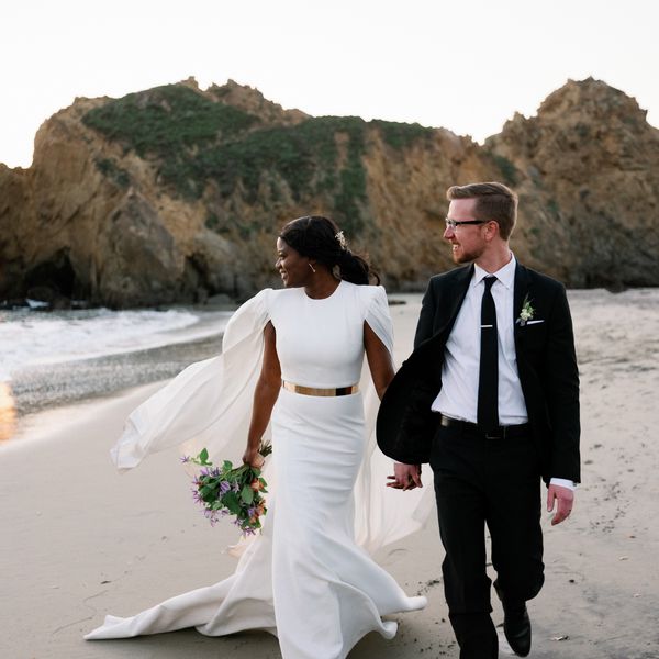 Couple Walks Along the Beach Holding Hands During Their Destination Elopement