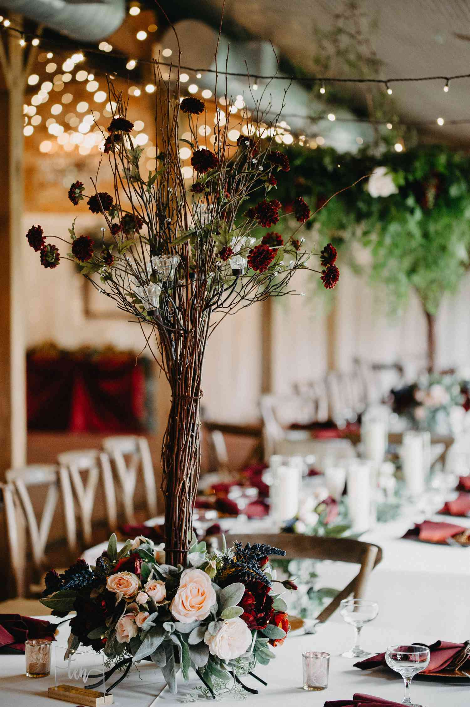 tree branch centerpiece with dark red blooms