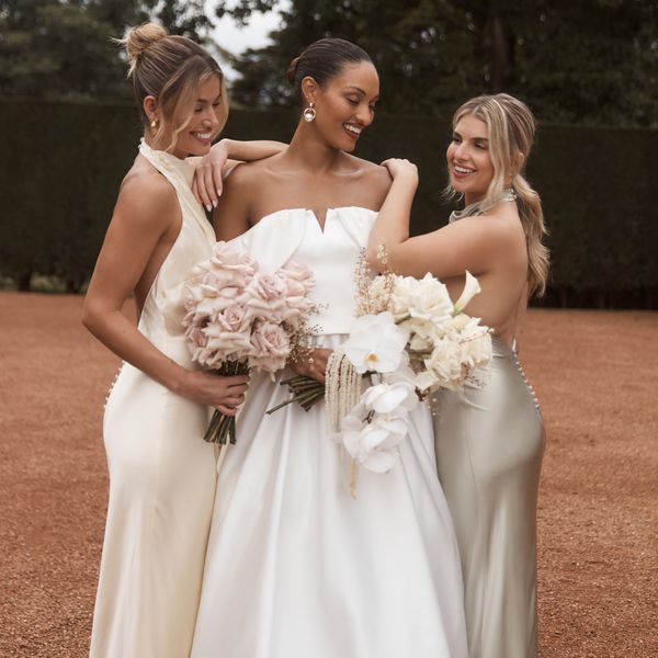 bride in a wedding dress posing with two bridesmaids