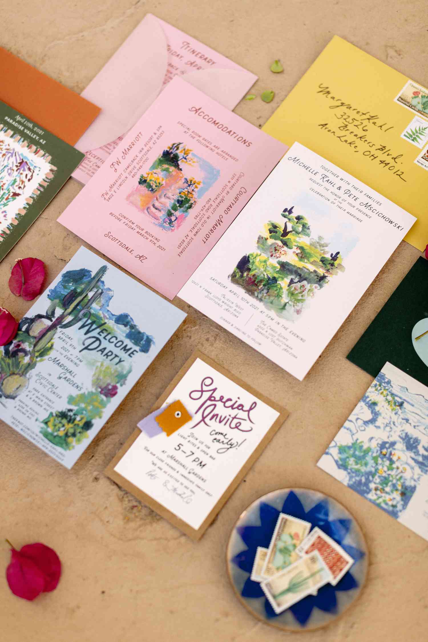 Invitation suite with pink, yellow, blue and white invitations with watercolor illustrations