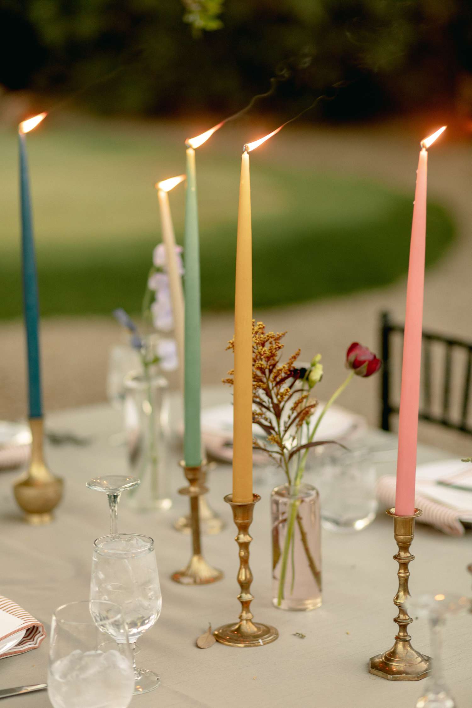 Multi-colored taper candles on wedding tablescape