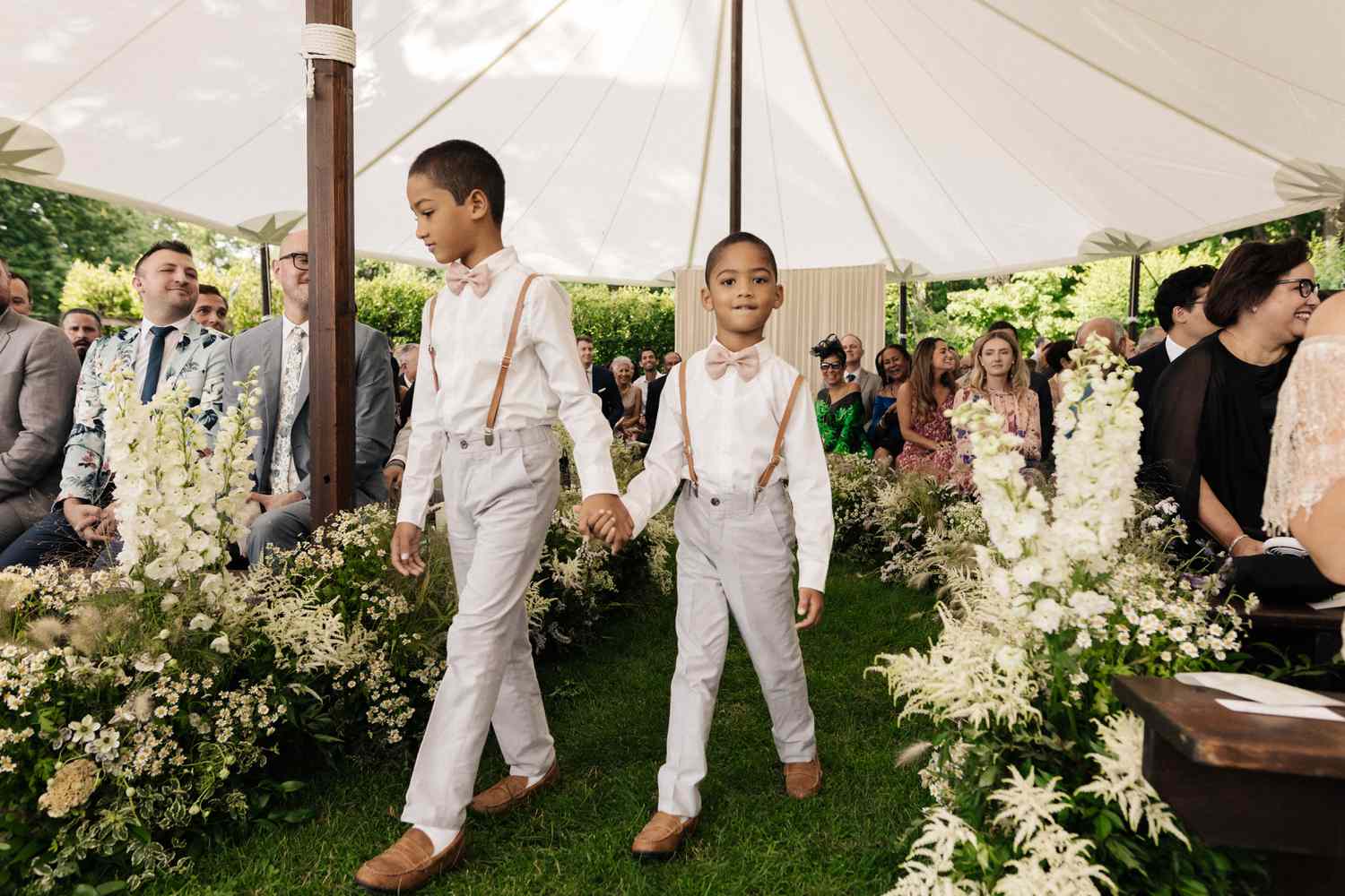 Page boys with gray trousers, brown suspenders and pink bow ties