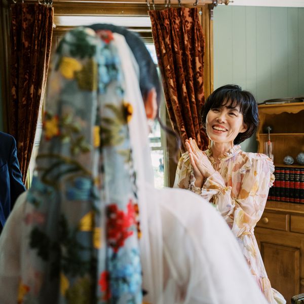 Bride's Mother in Long-Sleeve Dress With Abstract Pattern and Ruffles Looking at Daughter Wearing Colorful Veil