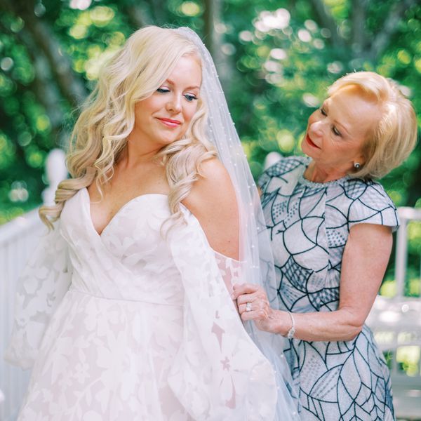 Mother of the Bride in Blue Dress and Daughter in Veil Posing for Photo 