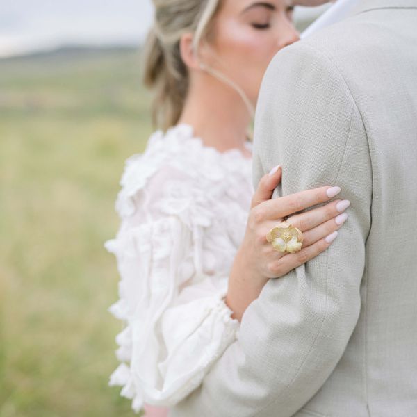 close-up of a woman's hand holding onto her partner's arm