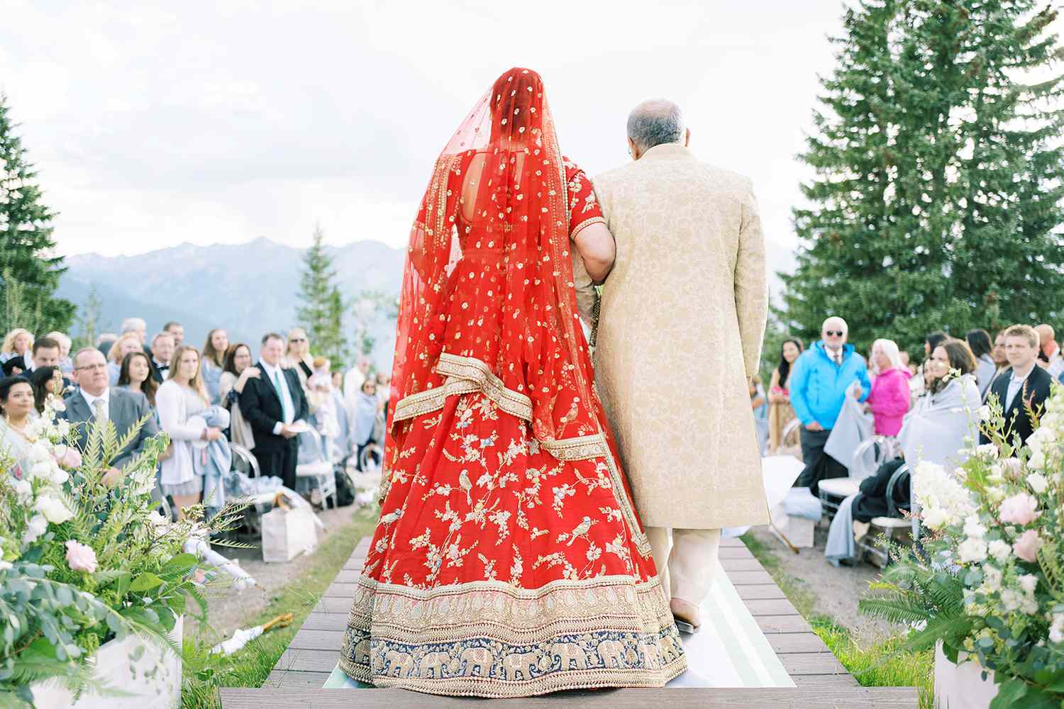 wedding processional for a traditional Indian wedding, bride in red Indian wedding attire.